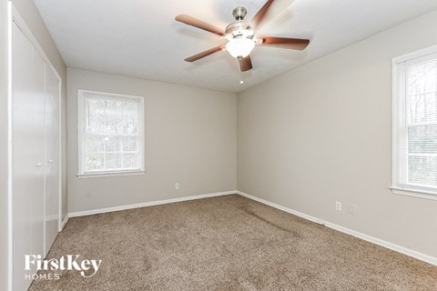 a bedroom with carpet and a ceiling fan