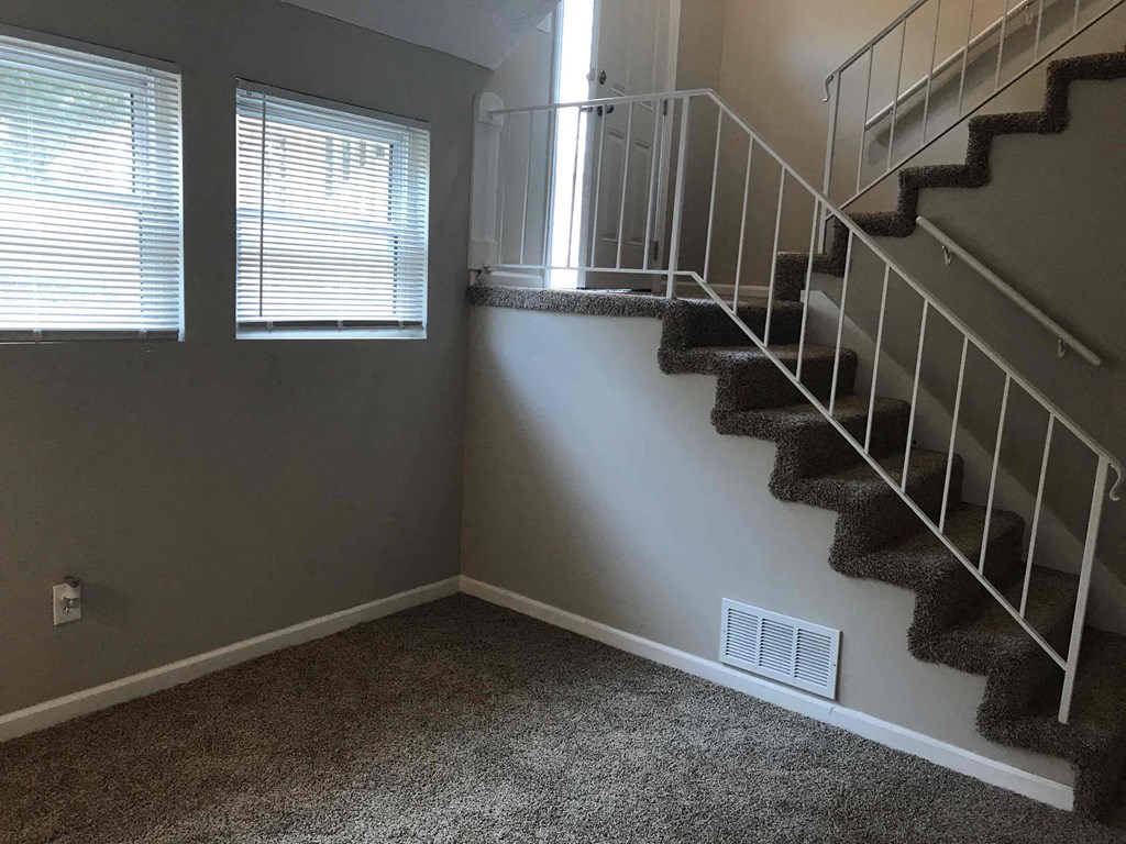 a set of stairs in a room with a window and