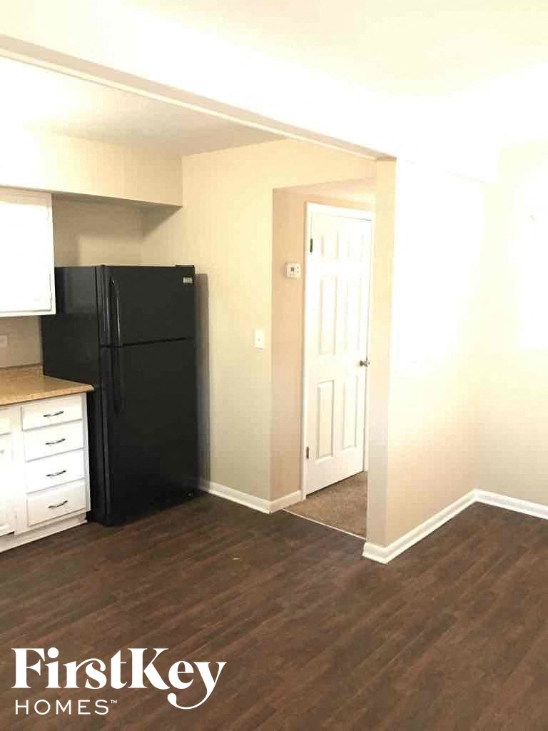 a kitchen with a black refrigerator and a door