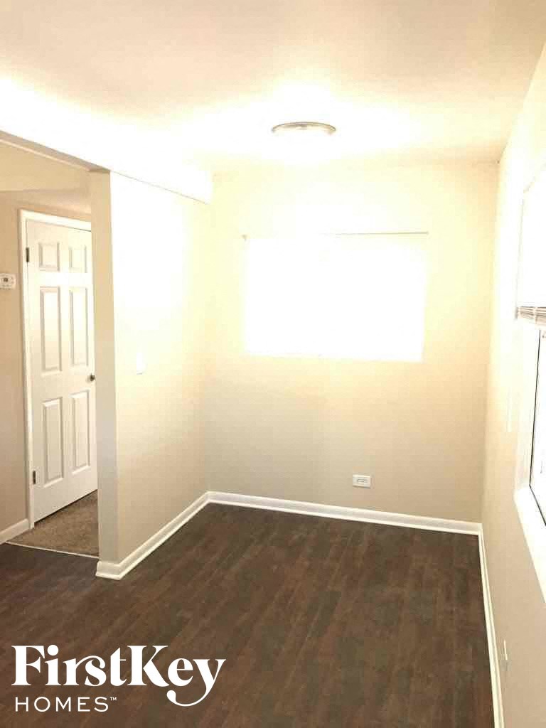 a empty room with wooden floors and a white door