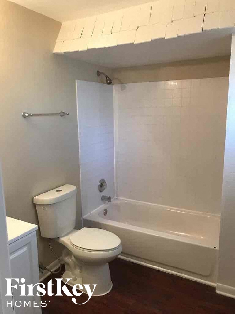 a white bathroom with a toilet and a tub