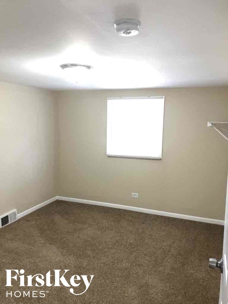 an empty room with a window and a carpet