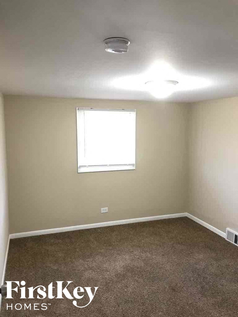 an empty room with a window and a carpet