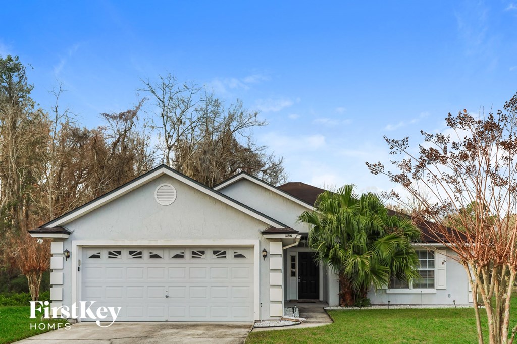 A white house with a garage is for sale.