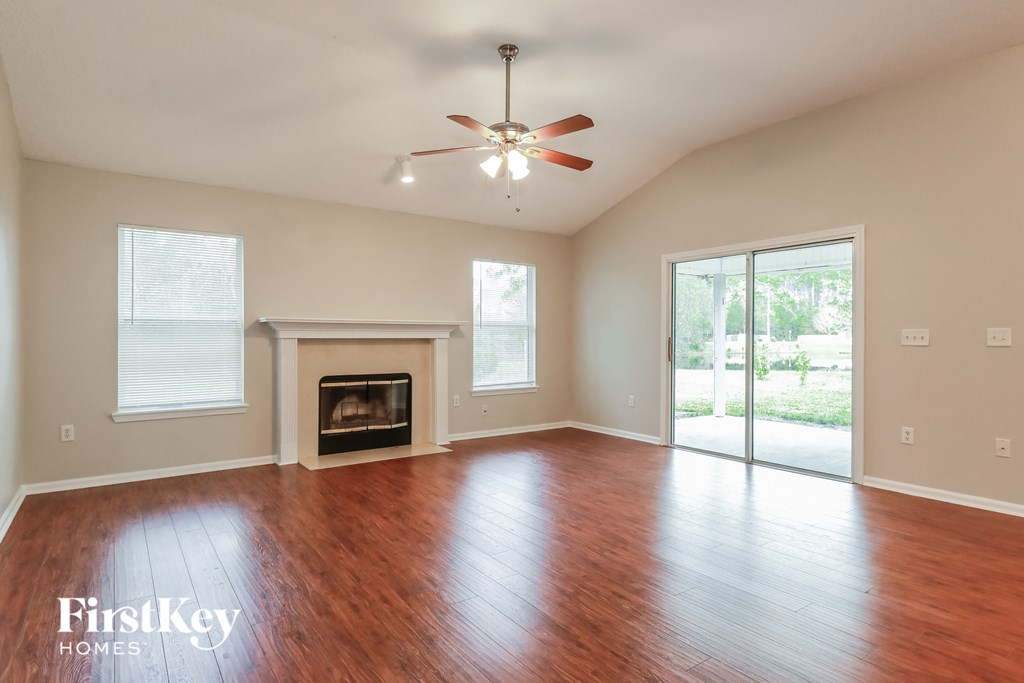 A spacious room with a fireplace and sliding glass doors.