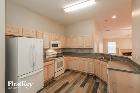 A kitchen with wooden cabinets and a white fridge.
