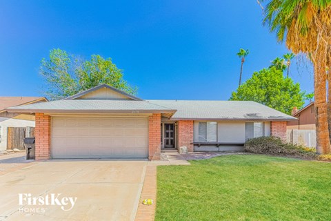 a house with a driveway and a palm tree