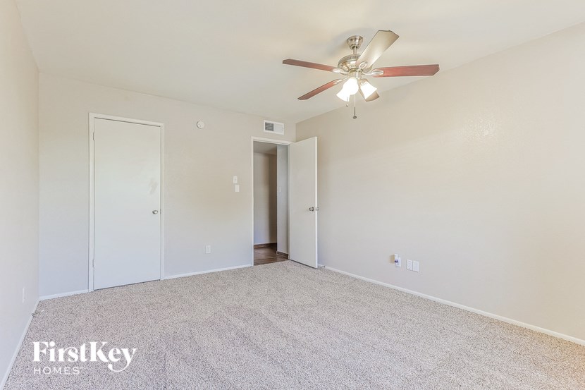 an empty living room with a ceiling fan
