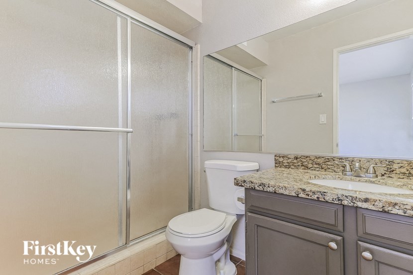 a bathroom with a toilet and a shower and a sink