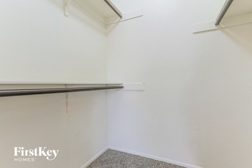 a white closet with a hanging rack on the wall