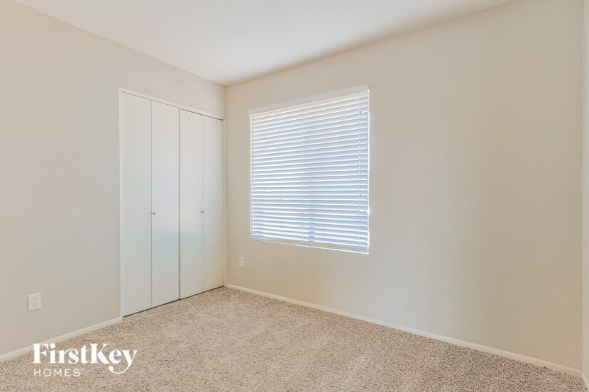 a bedroom with a window and a closet