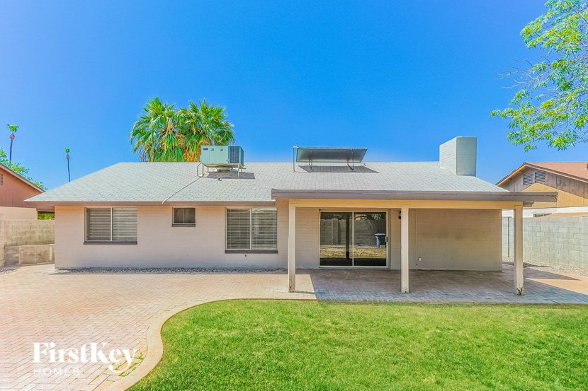 a white house with a lawn and a palm tree