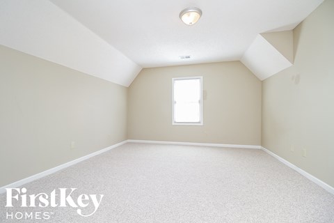 a bedroom with white carpet and a window