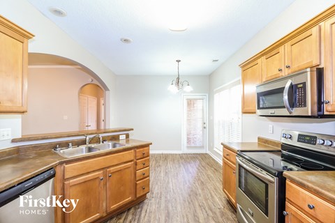 A kitchen with wooden cabinets and a stainless steel dishwasher.