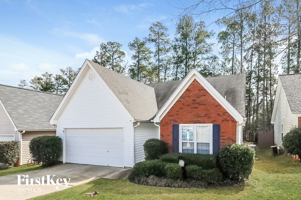 a small brick and with a yard and a driveway