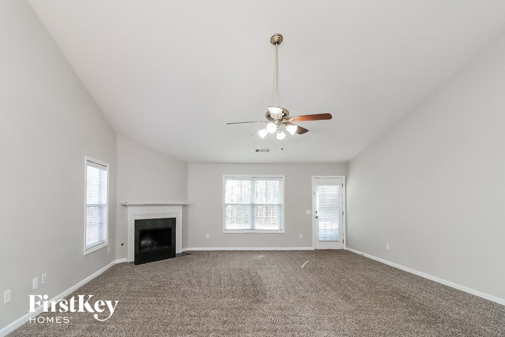 the living room with fireplace and ceiling fan