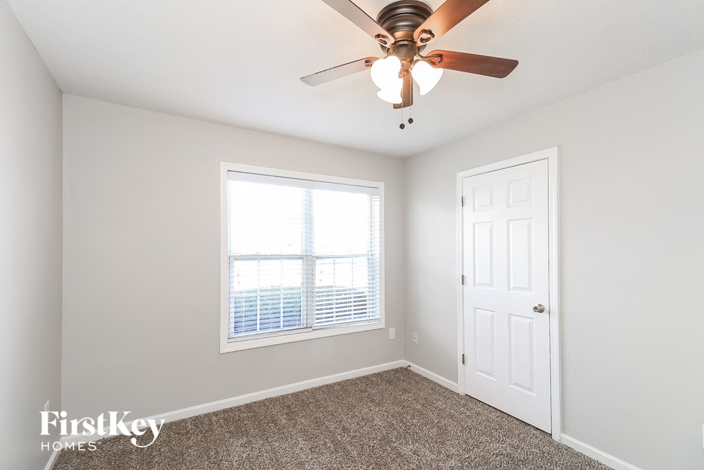 a bedroom with a ceiling fan and a window