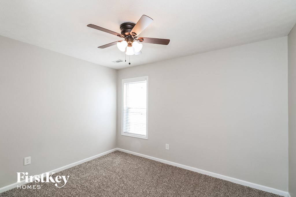a bedroom with a ceiling fan and a window