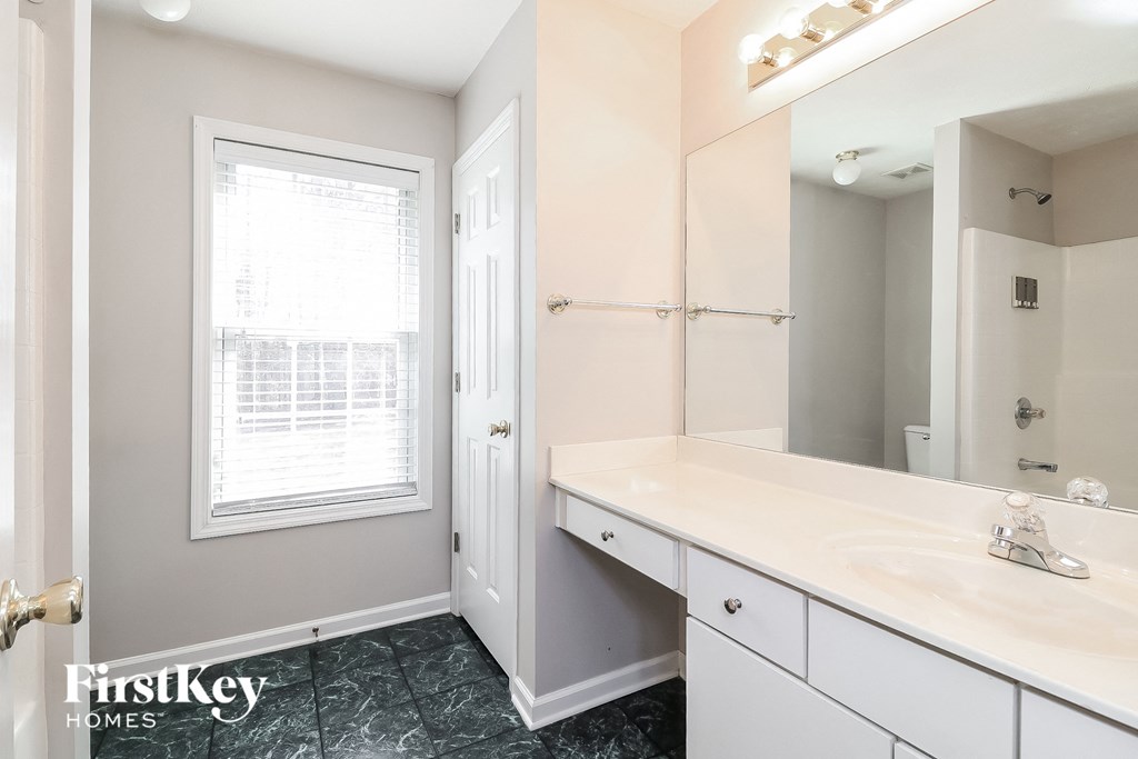 a bathroom with a sink and a mirror and a window
