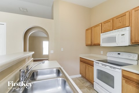 a kitchen with white appliances and wooden cabinets