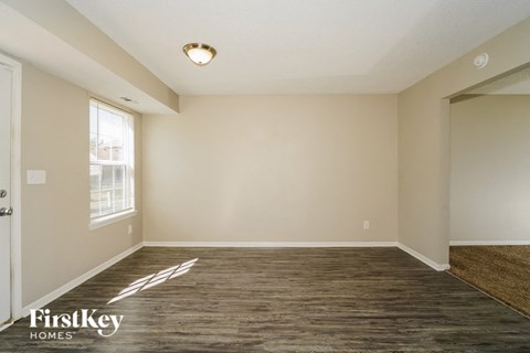 A room with wooden flooring and a window letting in natural light.