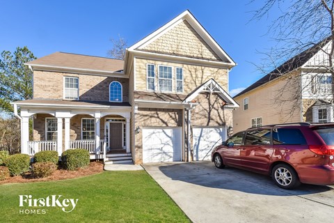 a home with a car parked on the driveway in front of it