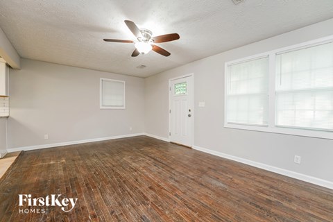 A room with wooden flooring and a ceiling fan.