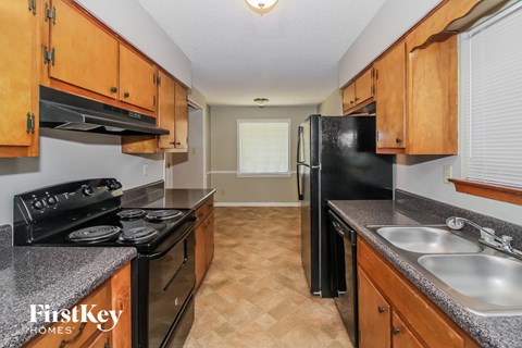 A kitchen with wooden cabinets and black appliances.