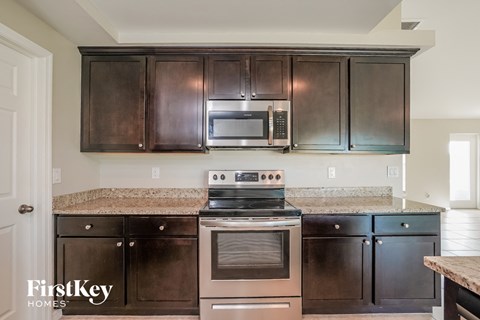 A kitchen with a stove top oven and microwave above a counter.