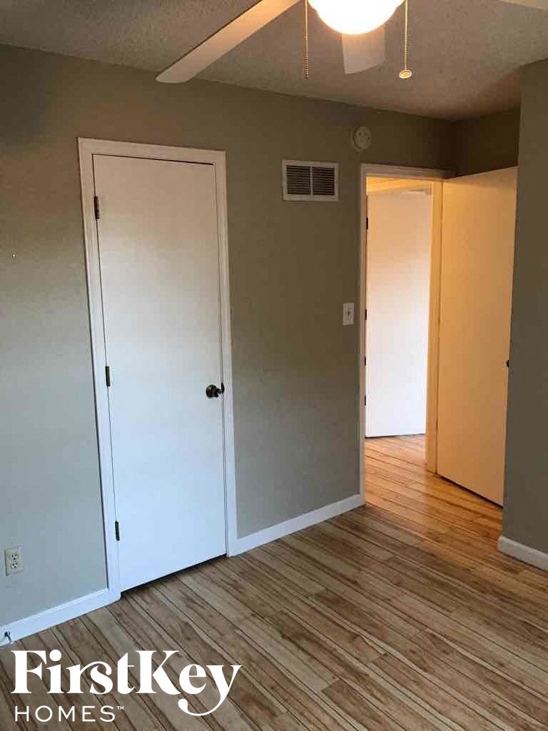 an empty room with a wood floor and white doors