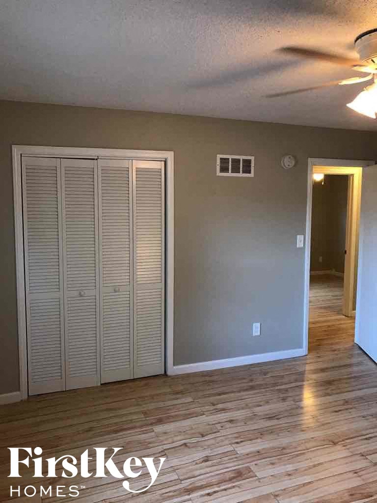 an empty living room with a wood floor and a closet