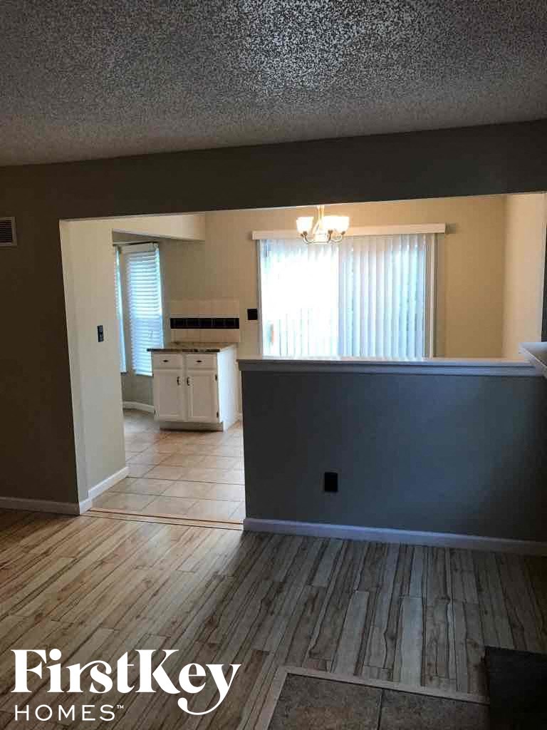 an empty house with a kitchen and a hard wood floor
