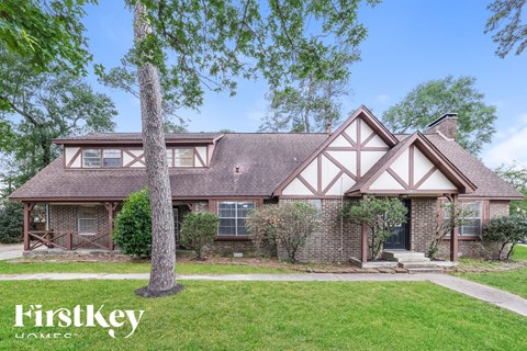 front view of a brick house with white trim and a yard