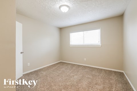 the upstairs bedroom with carpet and a window