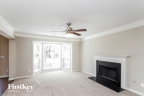 a living room with a fireplace and a ceiling fan
