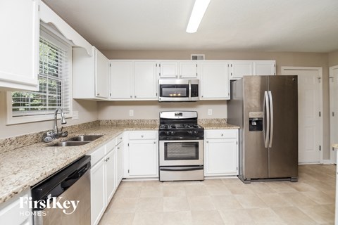 a kitchen with white cabinets and stainless steel appliances