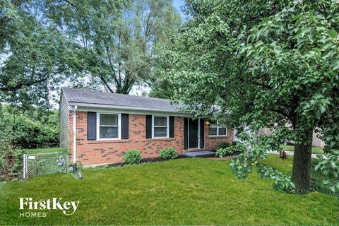 a small brick house with a yard and a tree