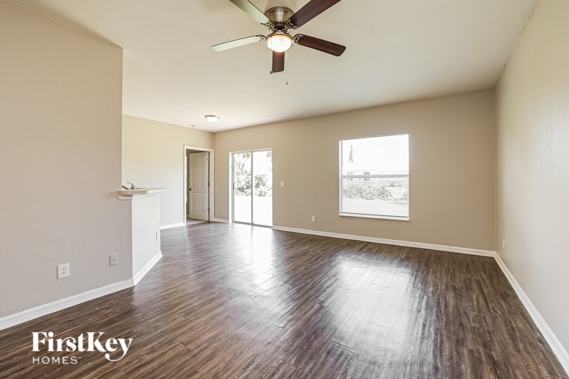A room with a ceiling fan and wooden flooring.