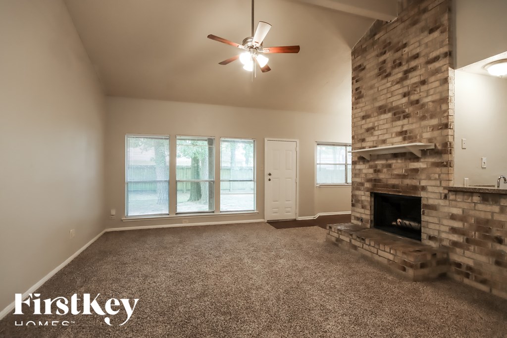A room with a fireplace and a ceiling fan.