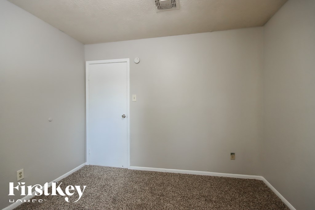 A room with a carpeted floor and a white door.