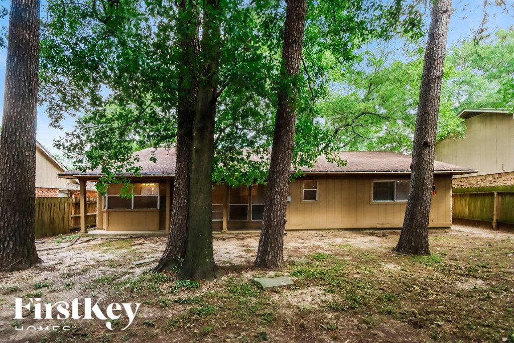 A house is surrounded by trees and has a brown exterior.