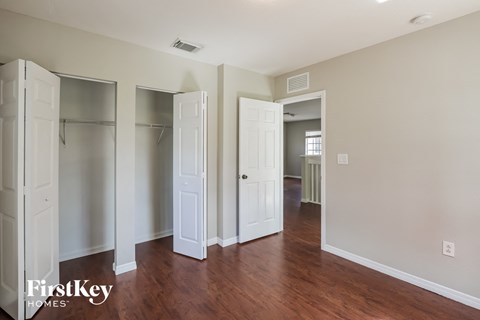 a renovated living room with wood floors and white closets