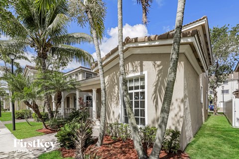 a home with palm trees in front of it