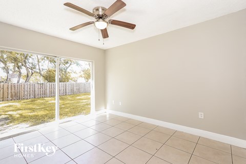 a living room with a large window and a ceiling fan