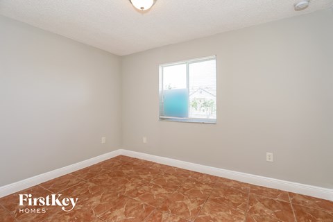 a bedroom with a window and a tiled floor