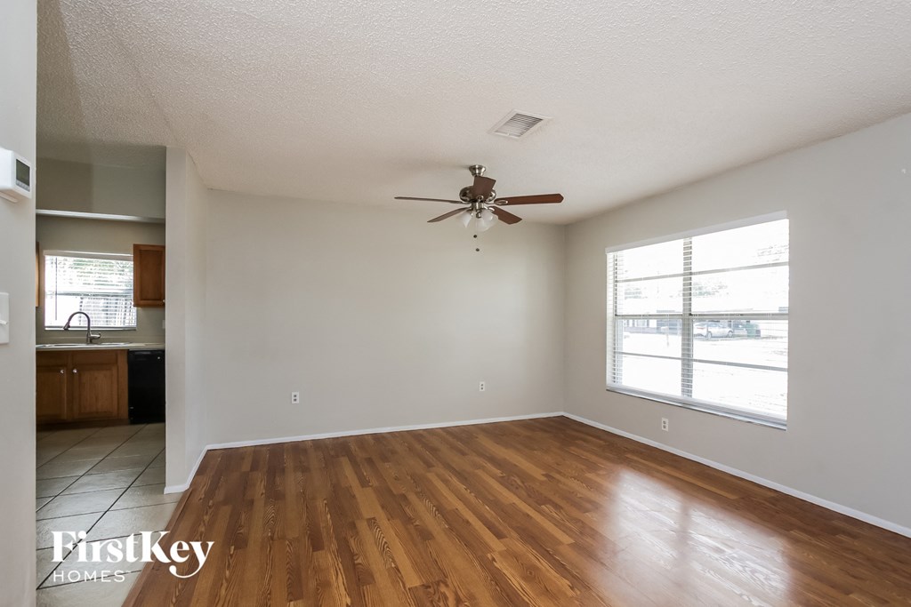 A room with wooden floors and a ceiling fan.