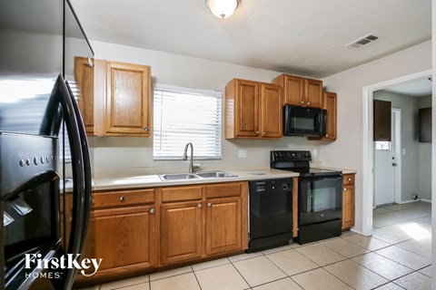 A kitchen with wooden cabinets and black appliances.