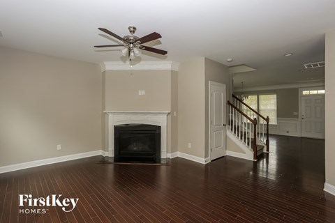 A living room with a fireplace and a staircase.