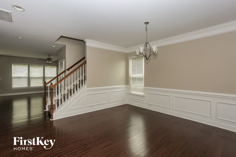 A spacious room with a staircase and a chandelier.