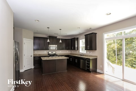 A modern kitchen with dark wood cabinets and a large island.